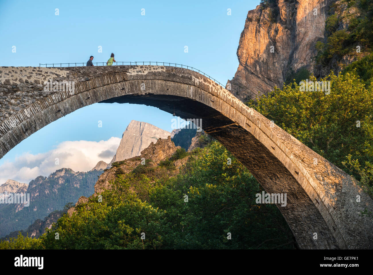 Il vecchio ponte in pietra attraverso il fiume Aoos in Konitsa con montatura Tymfi in background, Epiro, nel nord della Grecia. Foto Stock