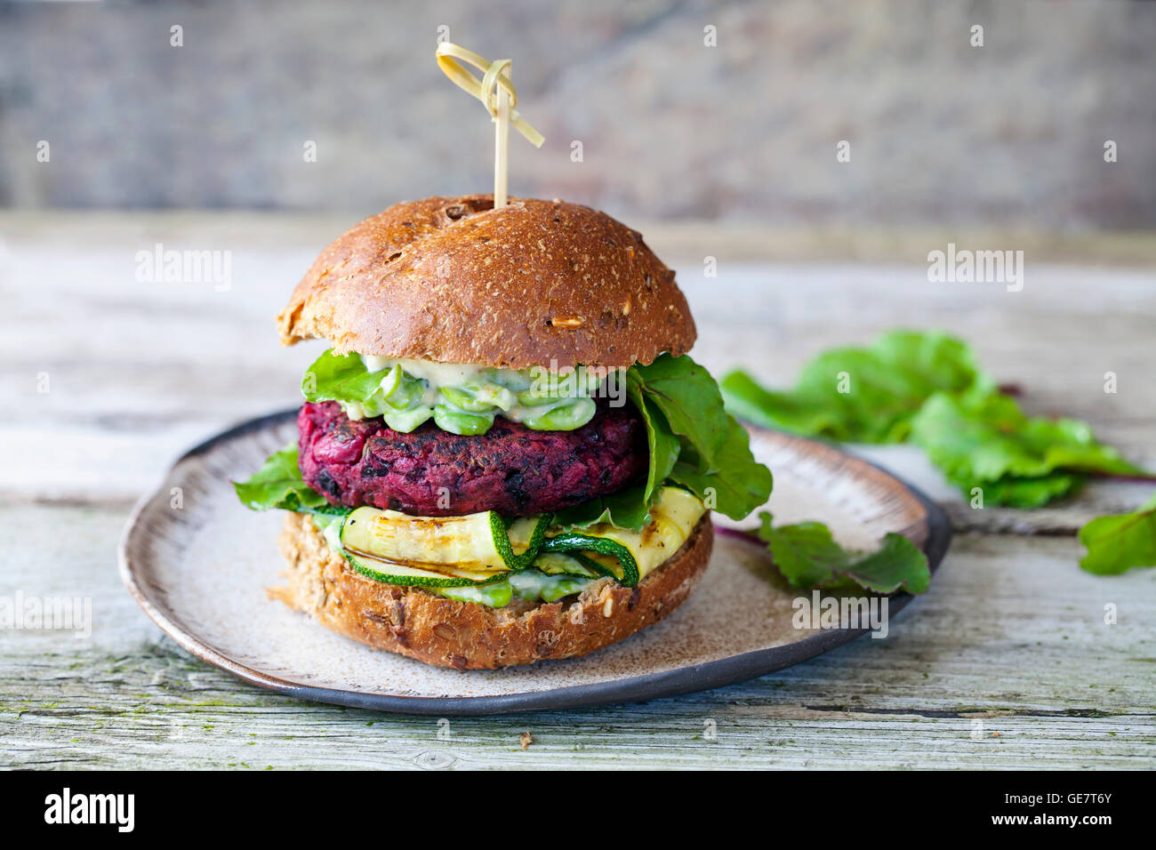 La barbabietola rossa vegetariano e fagioli neri burger con zucchine grigliate e fave Foto Stock