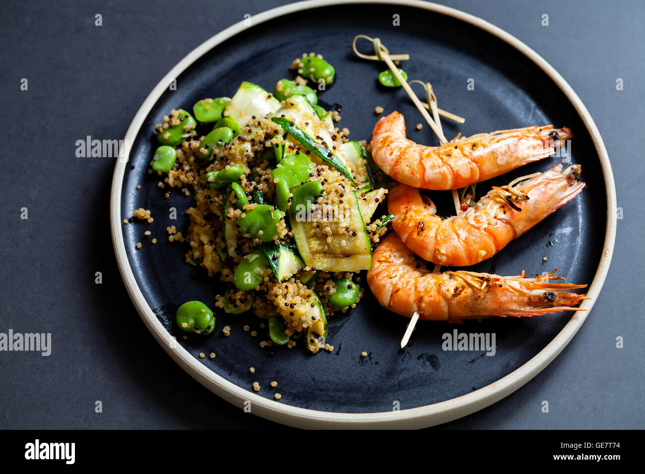 Grigliata di gamberi tigre con la quinoa, zucchine e ampia insalata di fagioli Foto Stock