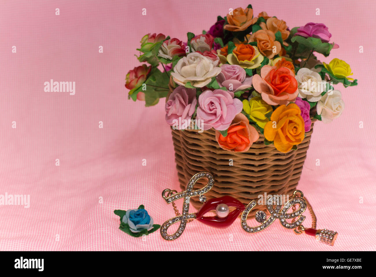 Bouquet di fiori di campo luminoso nel cestello sul modello rosa vintage di sfondo Foto Stock