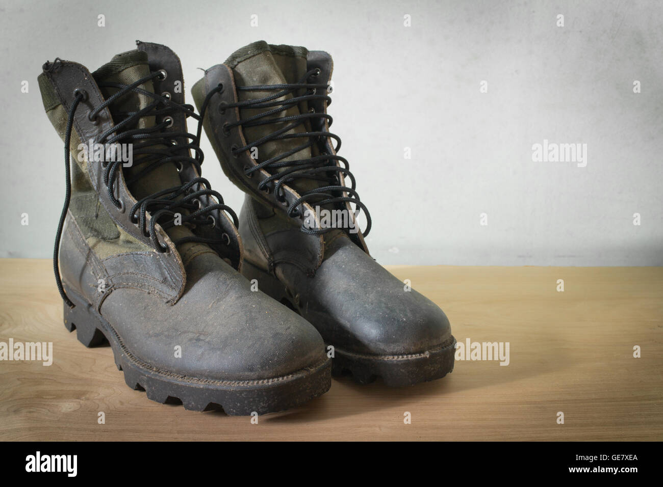 Vecchio jungle boot ancora in vita su uno sfondo di legno Foto Stock