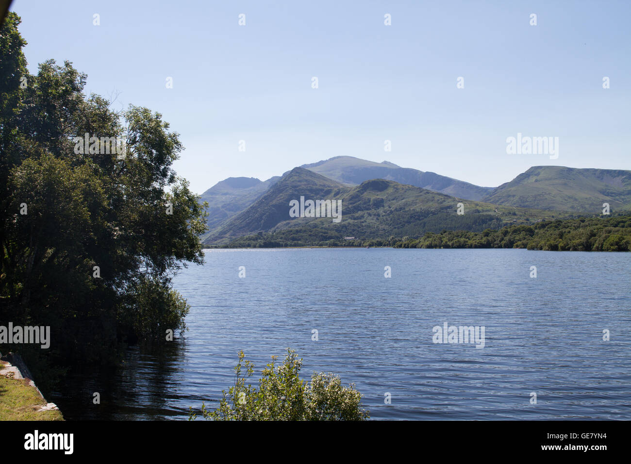 La vista di Snowdon dal vapore di bolina treno sul Llanberis Lake Railway su un luminoso cielo blu giornata d'estate Foto Stock