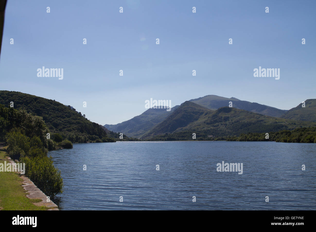 La vista di Snowdon dal vapore di bolina treno sul Llanberis Lake Railway su un luminoso cielo blu giornata d'estate Foto Stock