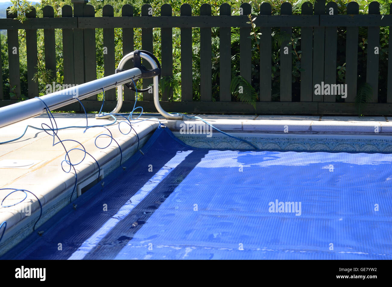 Copertura per piscina fuori il suo rullo e copertura della piscina Foto Stock