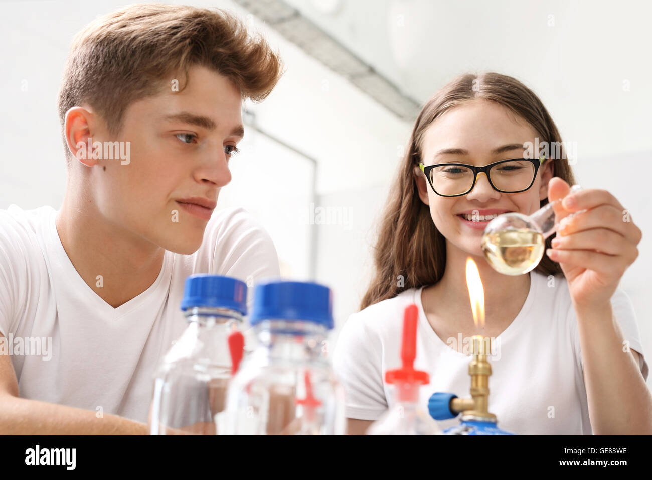 Schoolgirl esegue l esperienza di chimica. Foto Stock