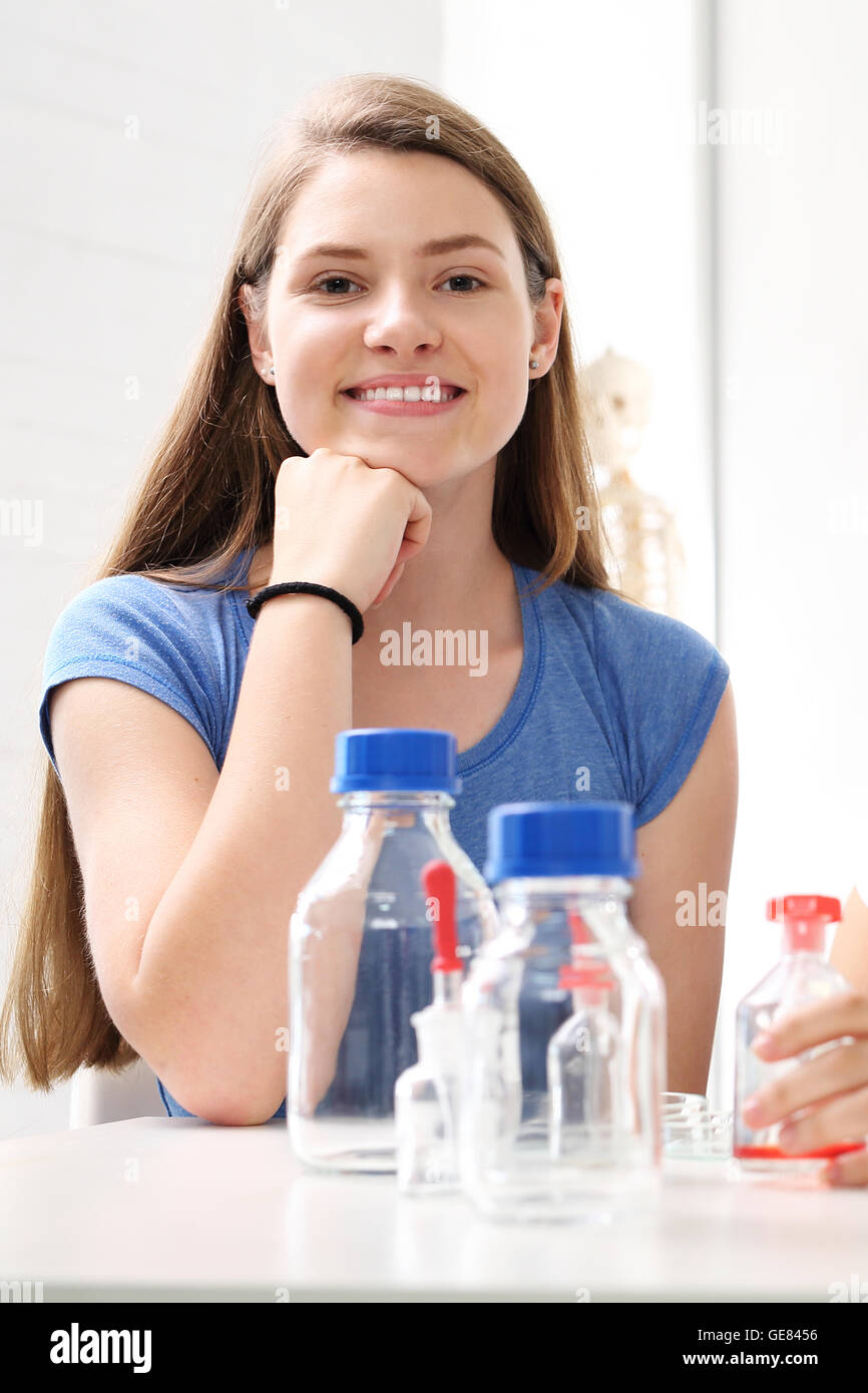 Schoolgirl esegue l esperienza di chimica. Foto Stock