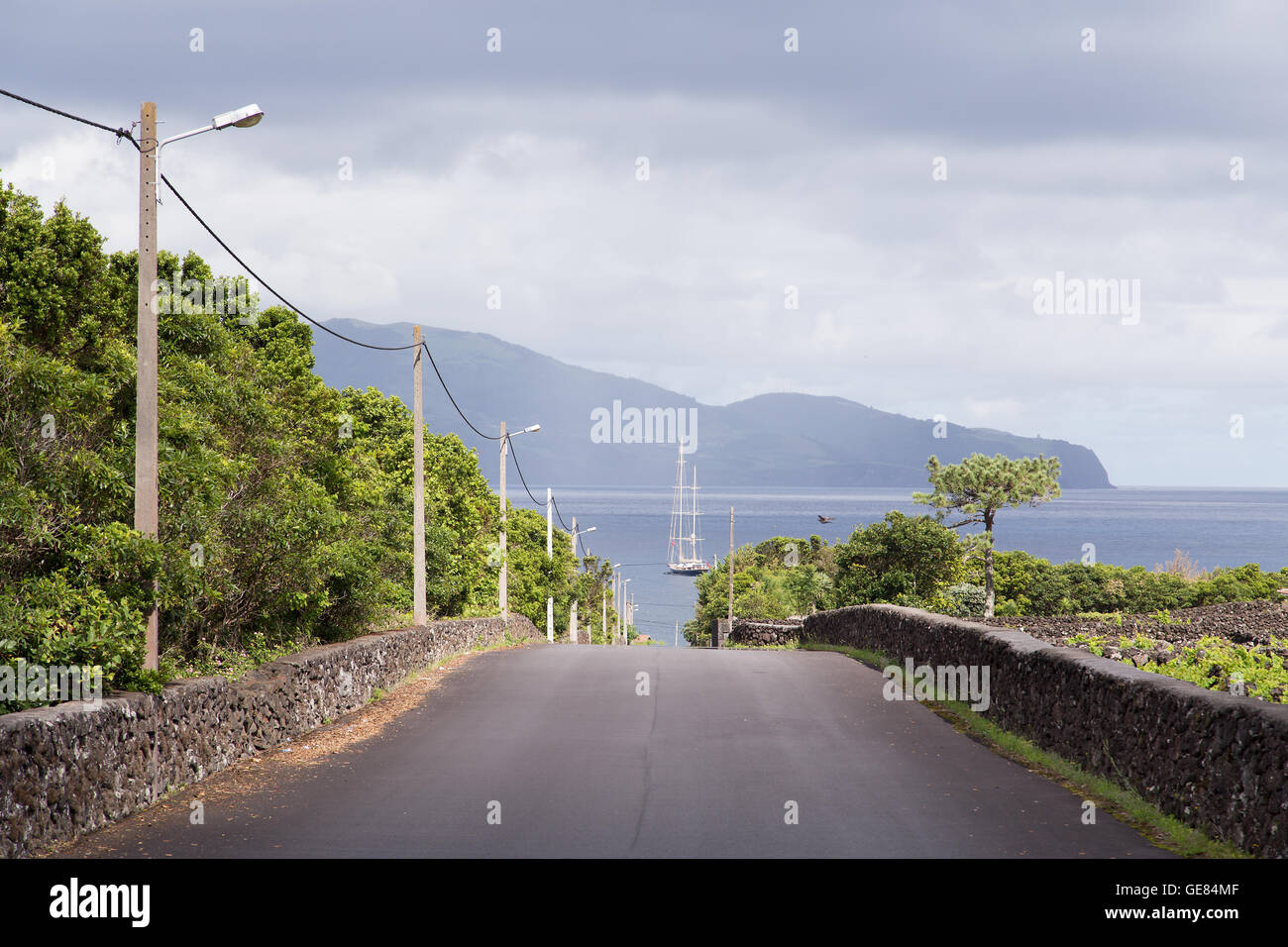 Paesaggio nell'isola di Pico, su una strada che porta al mare e sull'isola di Faial di fronte. Arcipelago delle Azzorre Foto Stock