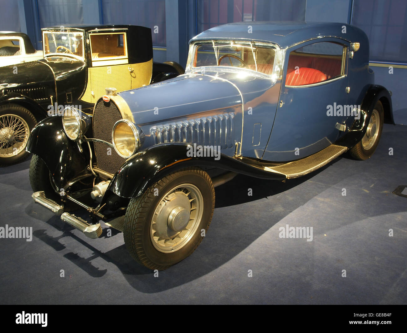 Questa immagine presenta una Bugatti blu con parafanghi neri, un'auto di lusso vintage nota per le sue prestazioni ed eleganza. Il design elegante e i colori ricchi mettono in risalto l'artigianalità e lo stile iconico del marchio Bugatti dei primi anni del XX secolo. Foto Stock