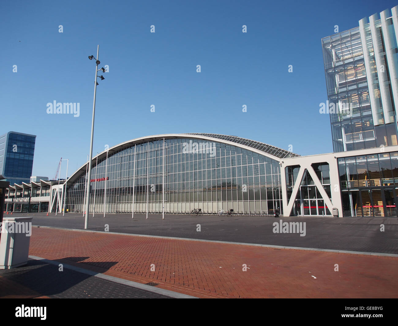 Questa fotografia mostra l'area Europaplein di Amsterdam, sede del centro congressi ed esposizioni RAI. Il design architettonico moderno contrasta con lo sfondo storico, mostrando lo sviluppo della città e il paesaggio urbano. Foto Stock