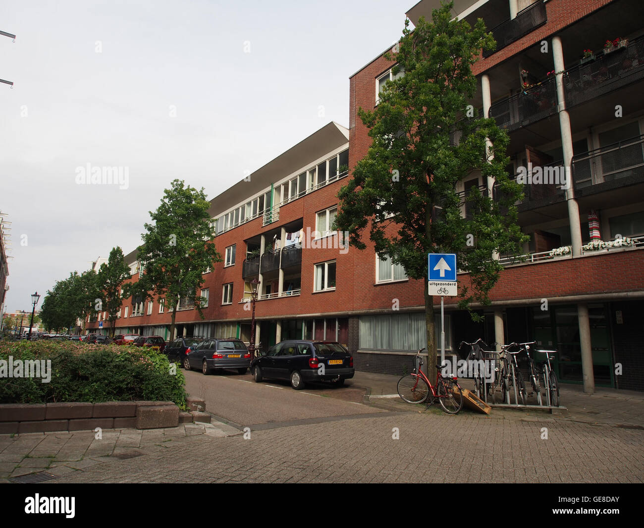 Una fotografia storica di Overamstelstraat, che cattura l'architettura della strada e il paesaggio urbano. Questa immagine fornisce informazioni sullo sviluppo del quartiere nel tempo. Foto Stock