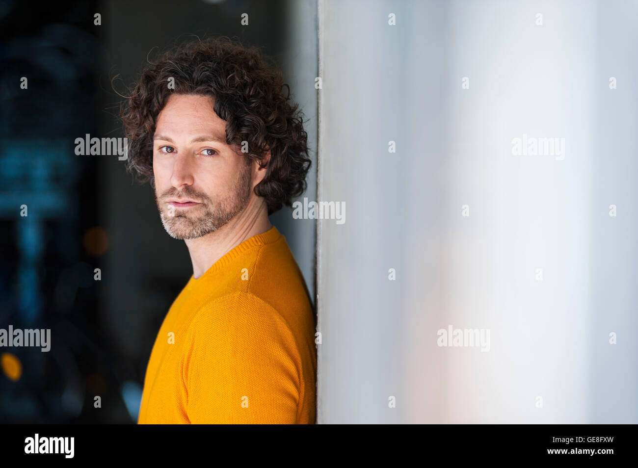 Ritratto di pensieroso uomo con parentesi marrone capelli appoggiata contro la parete Foto Stock