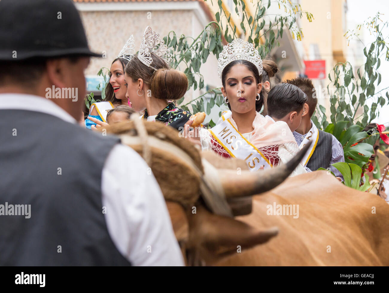 La Isleta, Las Palmas di Gran Canaria Isole Canarie Spagna, 23 luglio, 2016. Concorso di bellezza vincitore afferra un boccone veloce come essa viene portata in processione attraverso le strade di un bue disegnato il carrello durante la Fiesta del Carmen street parade di Las Palmas, la capitale di Gran Canaria Credito: Alan Dawson News/Alamy Live News Foto Stock