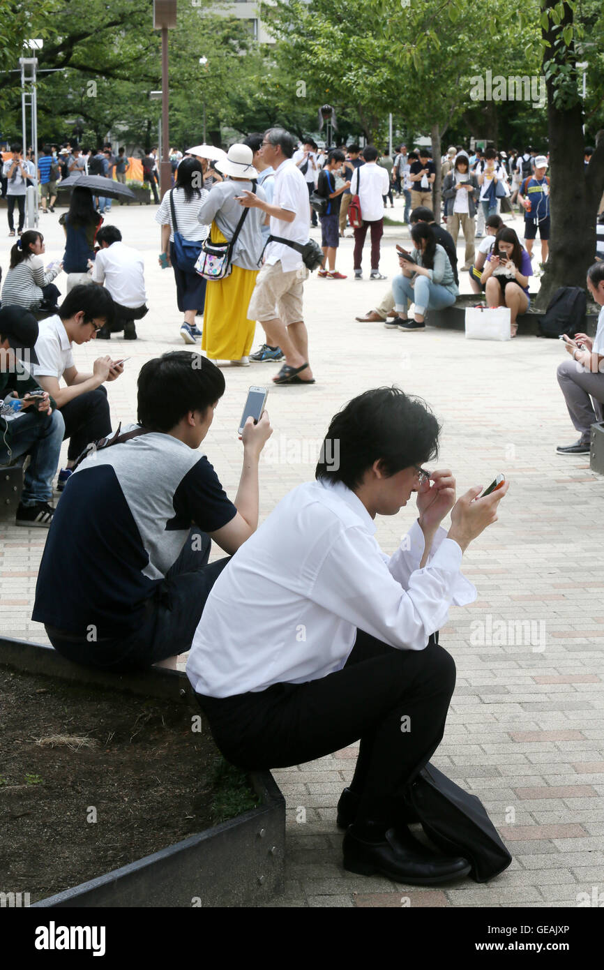Tokyo, Giappone. Il 24 luglio, 2016. Uomini e donne giovani e non-così-vecchio sono assorbiti nella riproduzione del Pokemon Go gioco dello smartphone in un centro di Tokyo park di Domenica, 24 luglio 2016. Fin dal suo arrivo in Giappone il venerdì, l'ultima moda in tutto il mondo sta già diventando un phaenomenon sociale nel paese in cui Pokemon, breve per Pocket Monster, un gioco Nintendos app rilasciato nel 1996. Credito: Haruyoshi Yamaguchi/AFLO/Alamy Live News Foto Stock