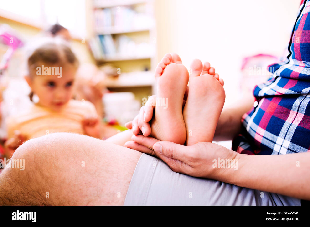 Bambine mettendo i suoi piedi nudi sul padre di giro Foto stock - Alamy