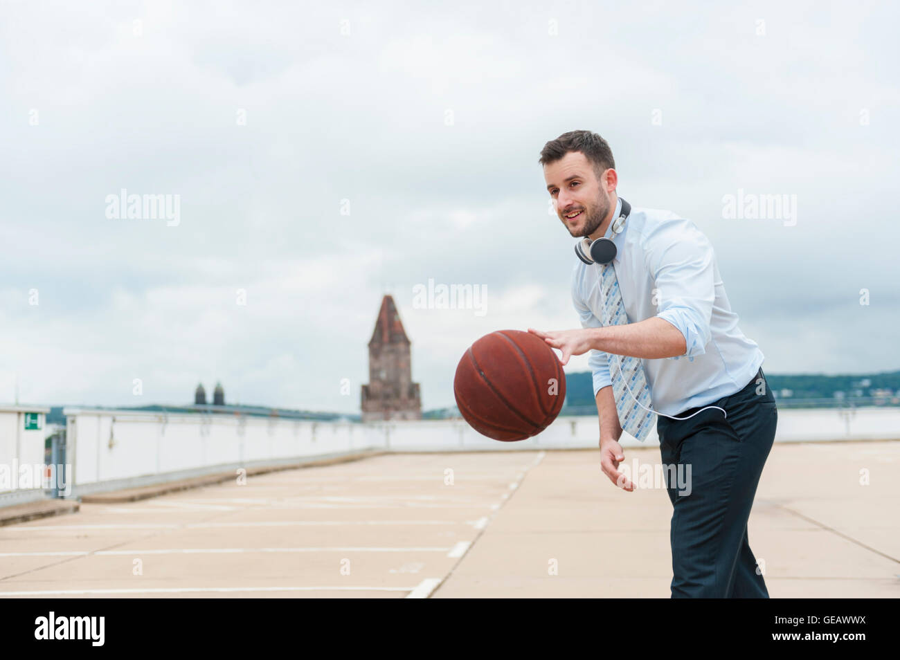 Imprenditore giocare a basket all'aperto Foto Stock