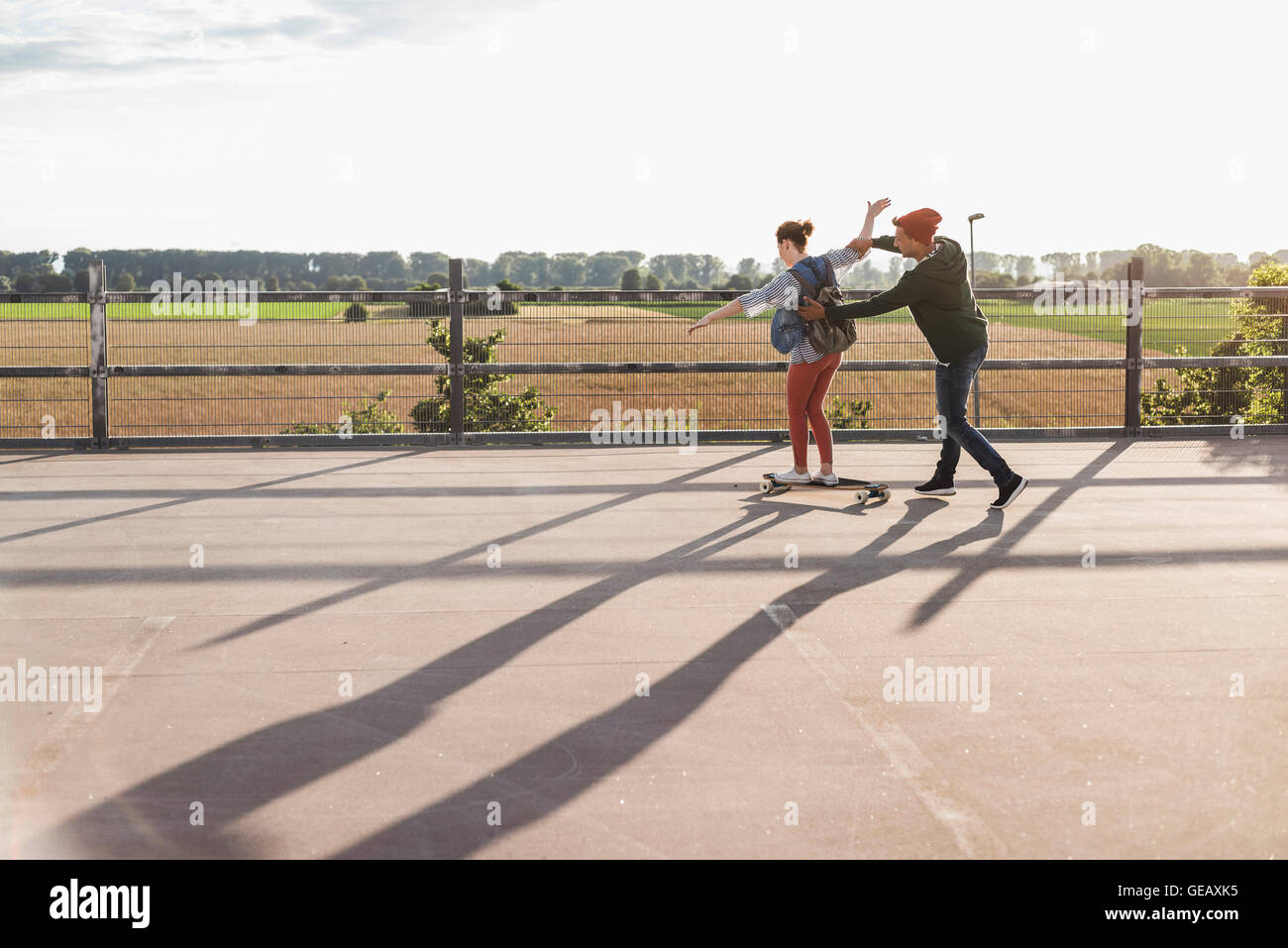 Coppia giovane con lo skateboard su parcheggio livello Foto Stock