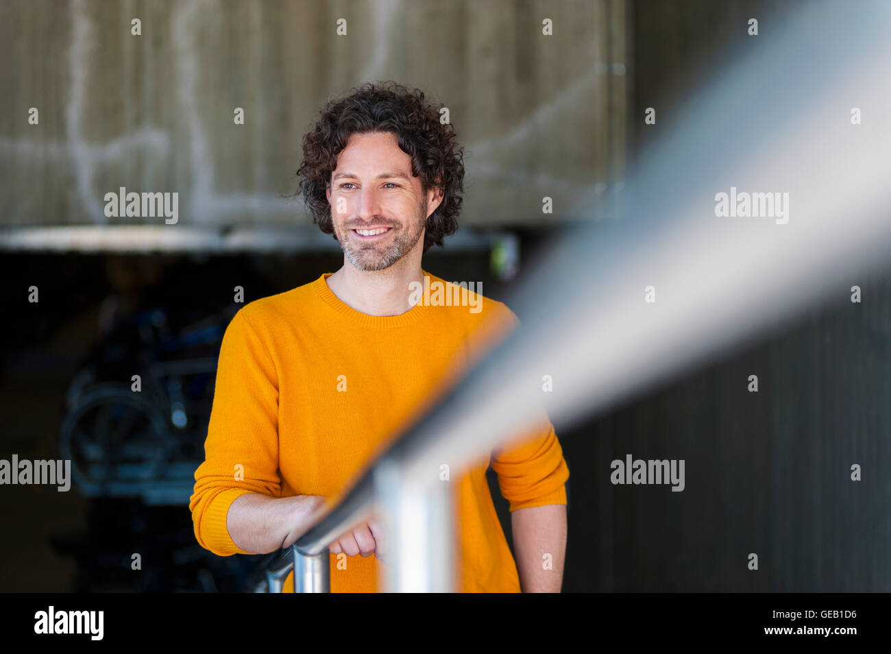 Ritratto di uomo sorridente con parentesi marrone capelli indossare pullover giallo Foto Stock
