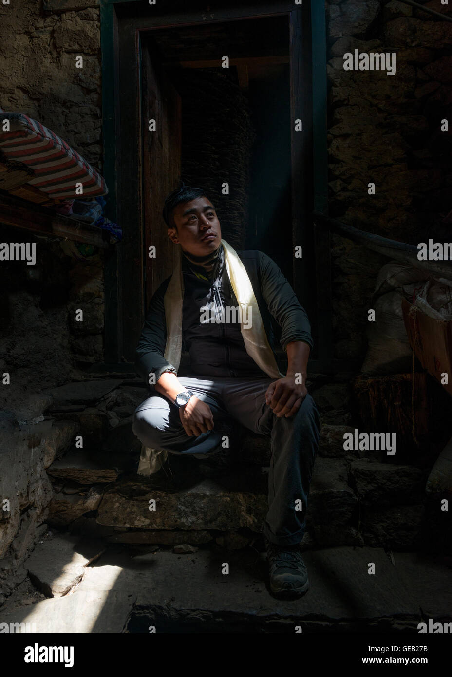 Raggio di luce che cade su di uomo seduto su stoop Foto Stock