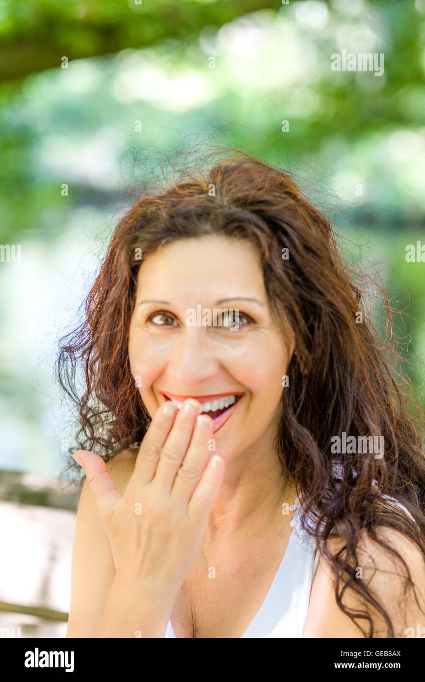 Scioccato ,donna con occhi spalancati che copre la bocca con la mano Foto Stock