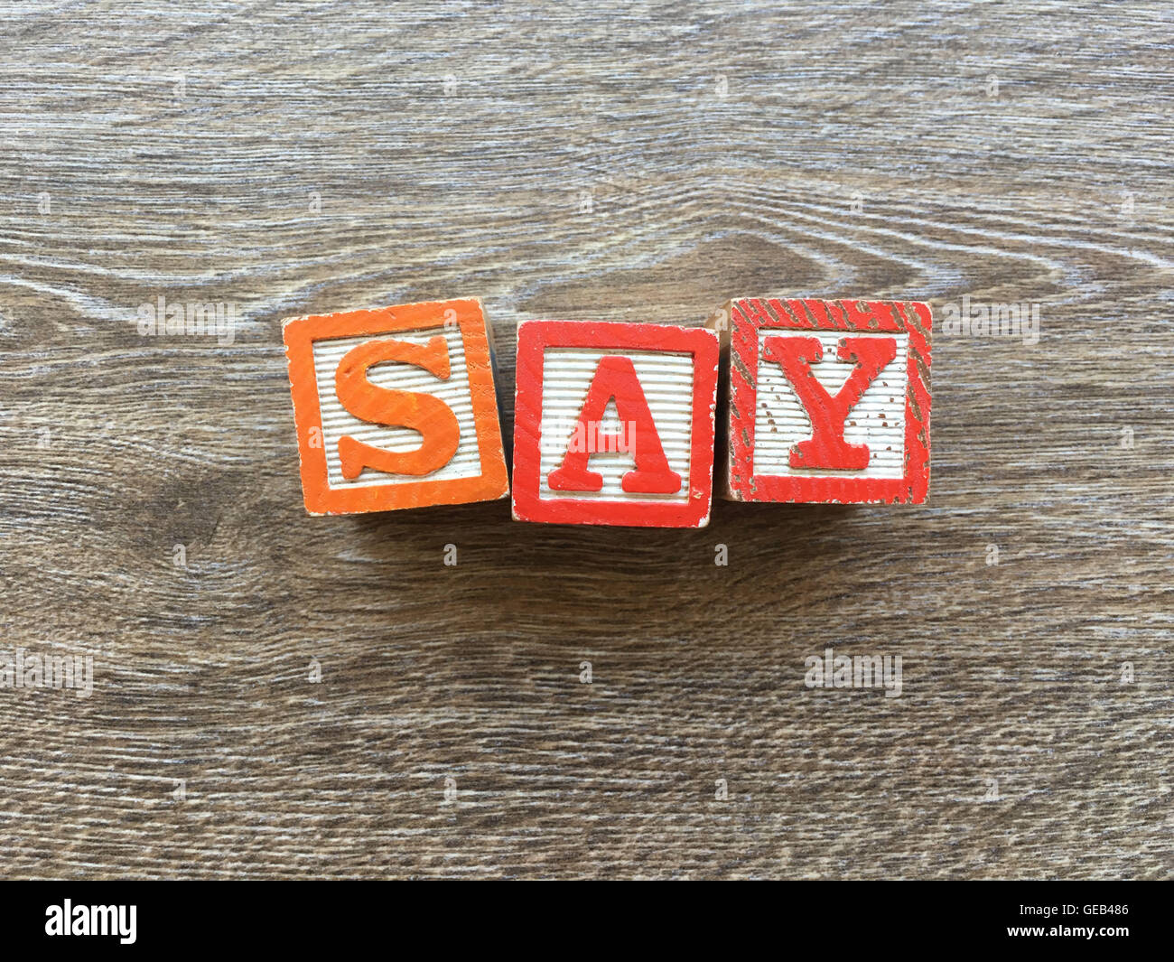 I blocchi di legno o cubetti di legno giocattoli con alfabeto lettere su di essi combinati insieme per creare la parola o verbo dire Foto Stock