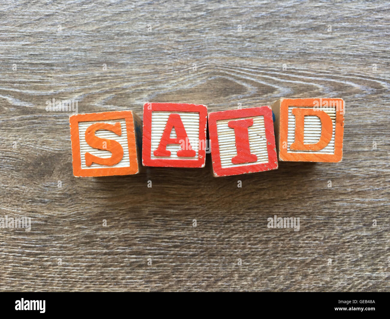 I blocchi di legno o cubetti di legno giocattoli con alfabeto lettere su di essi combinati insieme per creare la parola o verbo detto Foto Stock