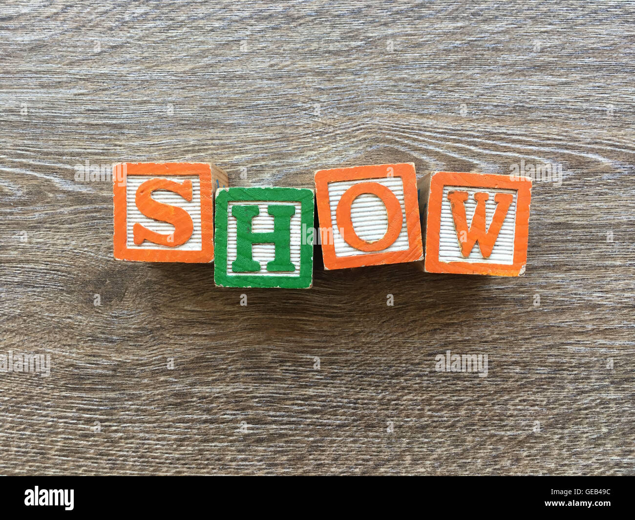 I blocchi di legno o cubetti di legno giocattoli con alfabeto lettere su di essi combinati insieme per creare la parola o verbo visualizza Foto Stock