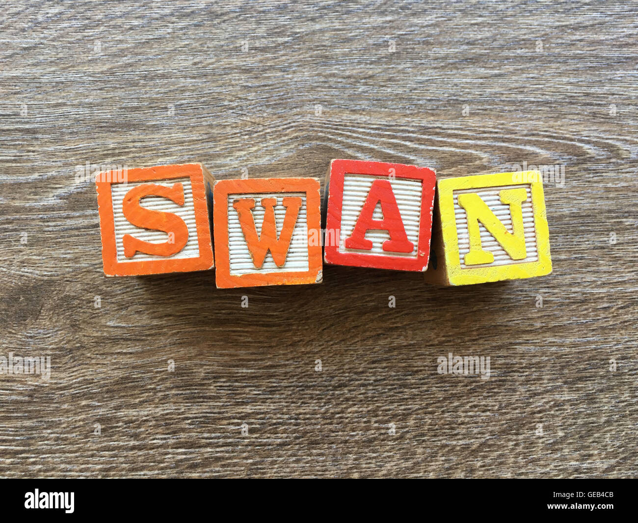 Alfabeto blocco di legno lettere che compongono la parola SWAN, combinando tali giocattoli lettere aiutare i bambini ad imparare e scrivere in inglese Foto Stock