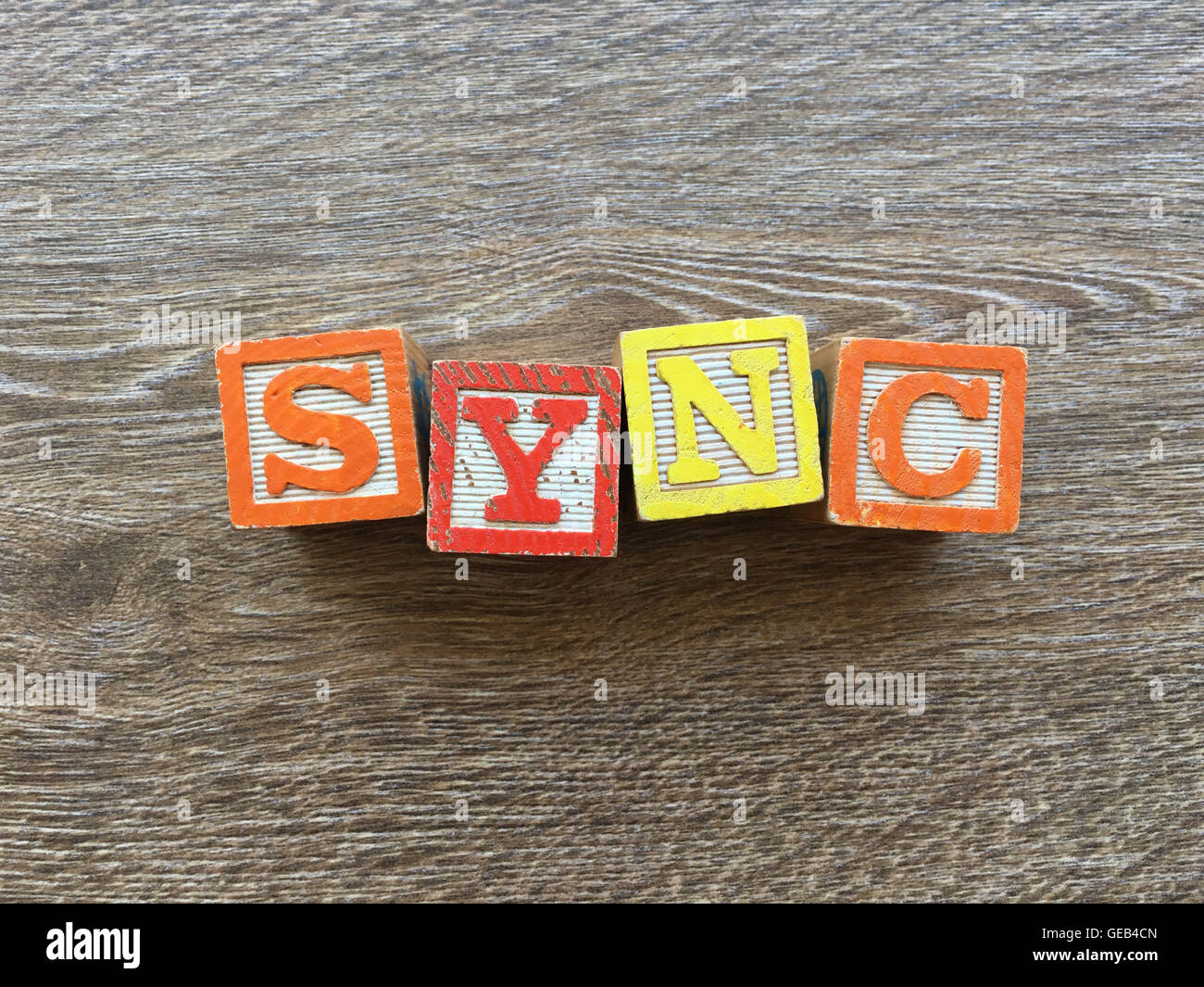 Alfabeto blocco di legno lettere che compongono la parola di sincronizzazione, la combinazione di tali giocattoli lettere aiutare i bambini ad imparare e scrivere in inglese Foto Stock