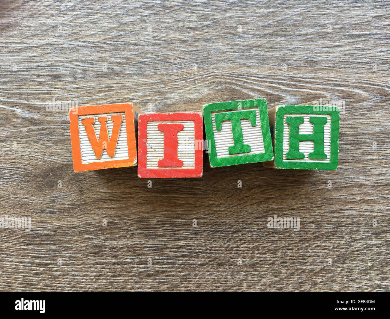 Alfabeto blocco di legno lettere che compongono la parola con, combinando tali giocattoli lettere aiutare i bambini ad imparare e scrivere in inglese Foto Stock