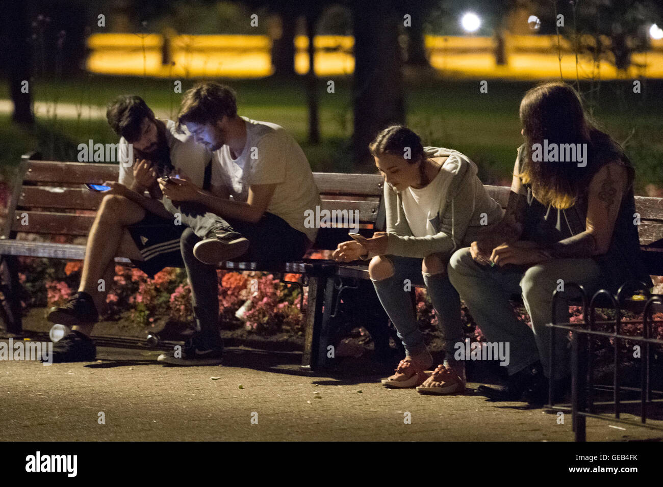 I giocatori di Pokemon fuori giocare catturare Pokemon a tarda notte in una folla in un parco a Cardiff, nel Galles del Sud. Foto Stock