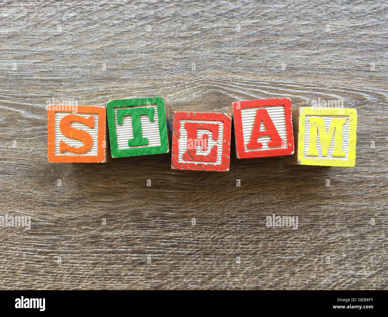 Alfabeto blocco di legno lettere che compongono la parola vapore, combinando tali giocattoli lettere aiutare i bambini ad imparare e scrivere in inglese Foto Stock