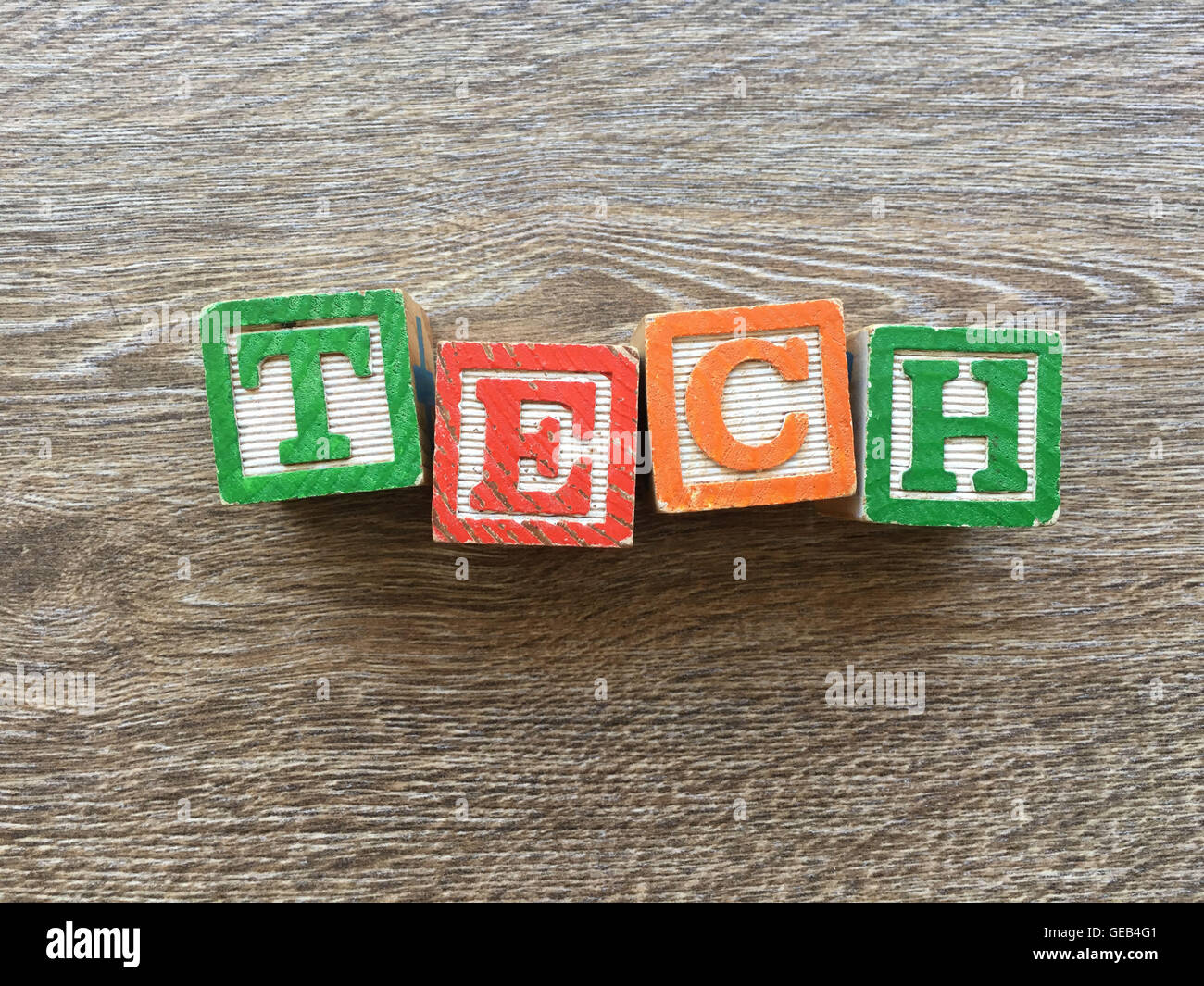 Alfabeto blocco di legno lettere che compongono la parola TECH, combinando tali giocattoli lettere aiutare i bambini ad imparare e scrivere in inglese Foto Stock
