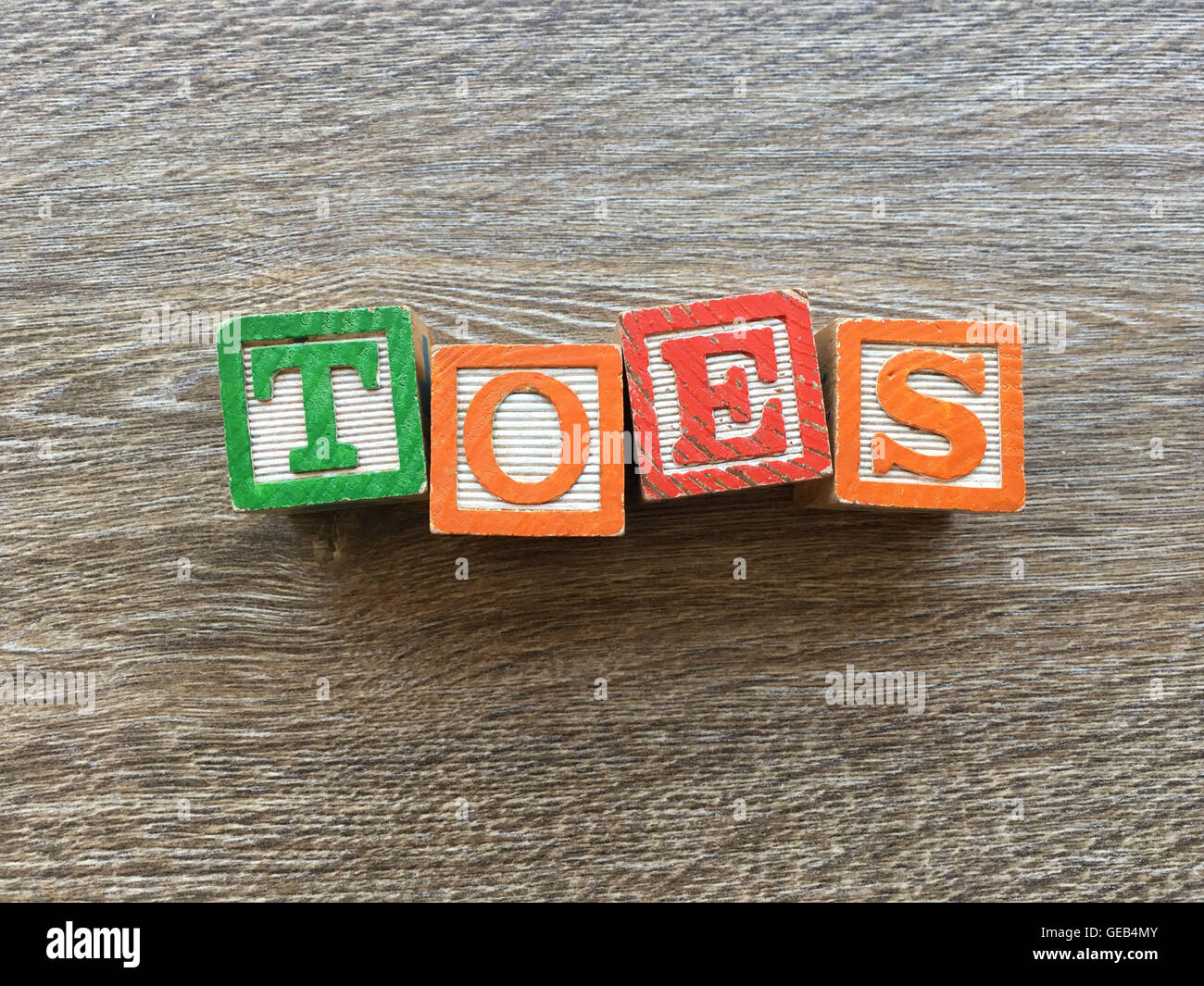 Alfabeto blocco di legno lettere che compongono la parola DITA, combinando tali giocattoli lettere aiutare i bambini ad imparare e scrivere in inglese Foto Stock