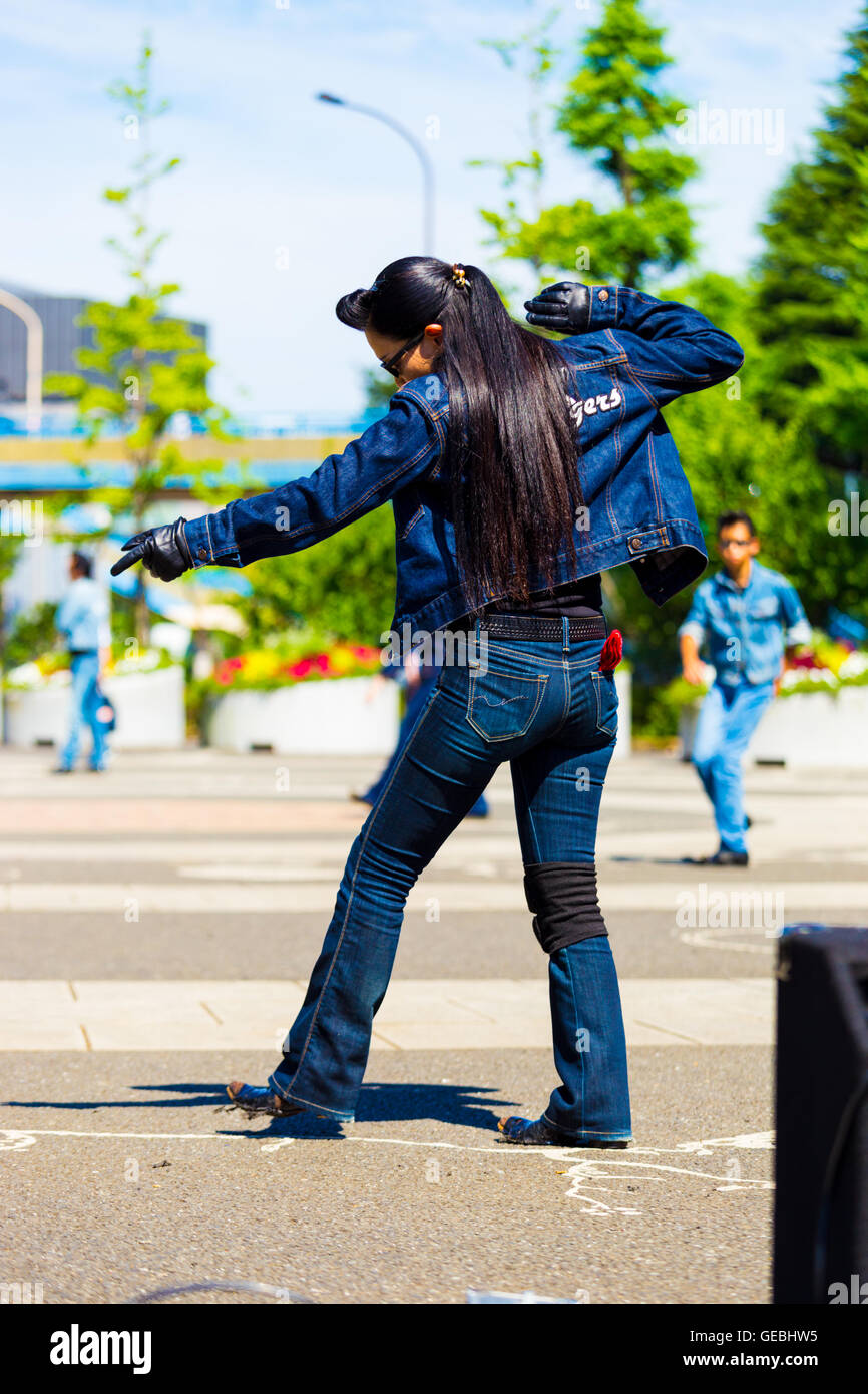 Parte posteriore della femmina di rockabilly ballerino in piena jean vestito e vintage pettinatura a ballare il rock and roll music weekly a Yoyogi Park Foto Stock