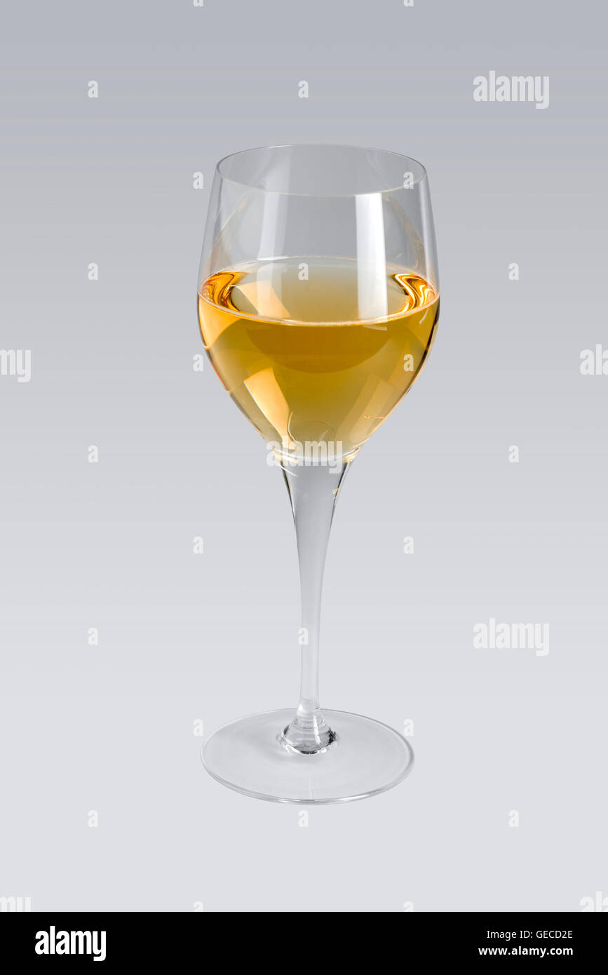 Bicchiere da vino parzialmente riempita con il vino bianco in grigio indietro Foto Stock