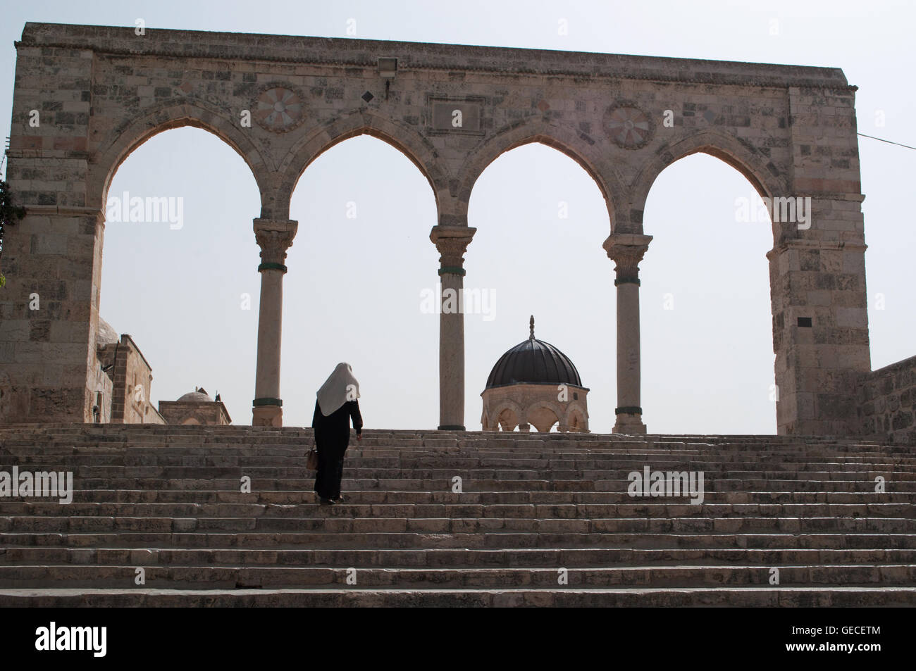 Gerusalemme: una donna musulmana sulla causeway con archi sul Monte del Tempio, uno dei più importanti siti religiosi in tutto il mondo Foto Stock