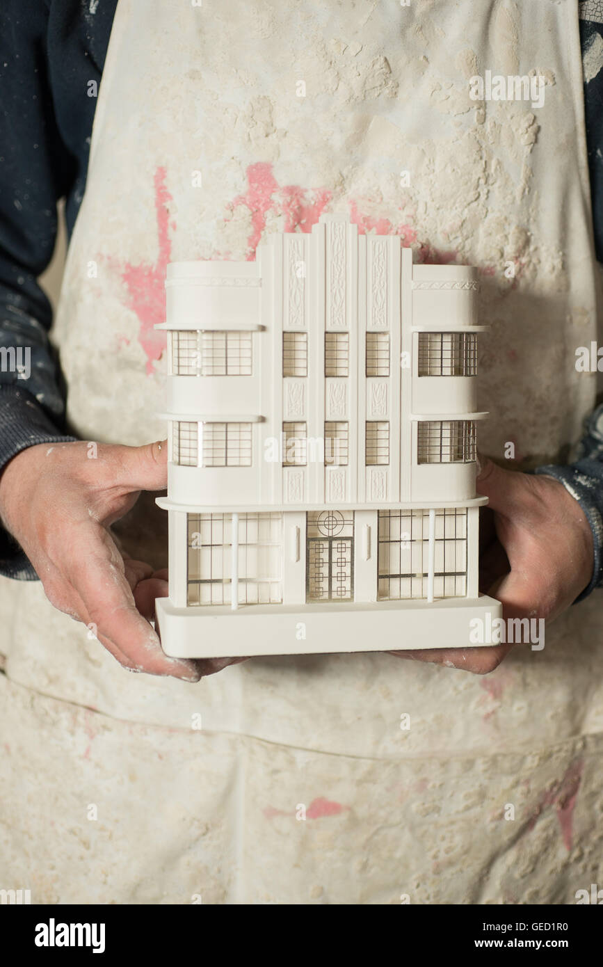 Un intonaco modello in scala di un noto edificio architettonico tenuto con due mani di una persona. Foto Stock