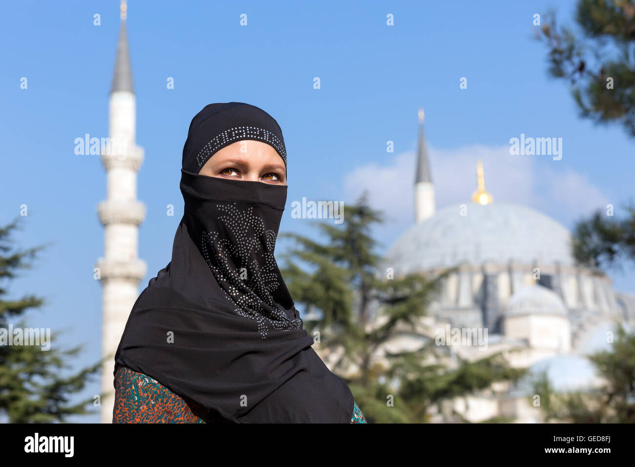 Ritratto di bella donna araba nel tradizionale abbigliamento musulmano Medio Oriente paesaggio urbano con la moschea e minareti su Backg Foto Stock