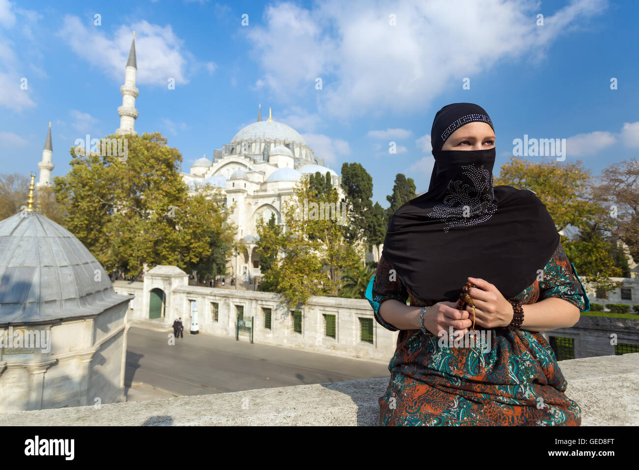 Ritratto di bella donna araba nel tradizionale abbigliamento musulmano Medio Oriente paesaggio urbano con la moschea e minareti su Backg Foto Stock