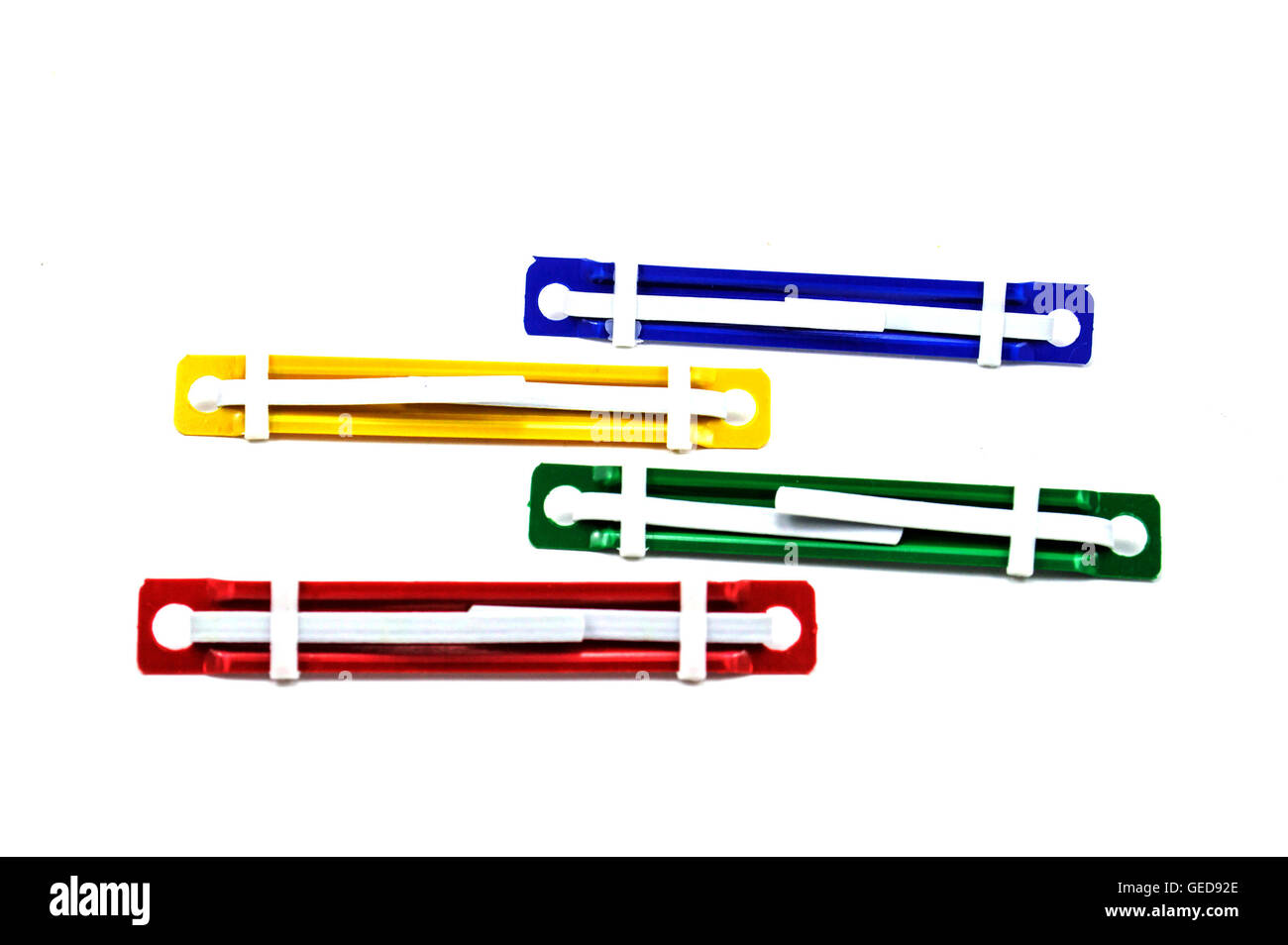 Carta colorata di dispositivi di fissaggio giallo blu verde rosso separati in background isolato Foto Stock