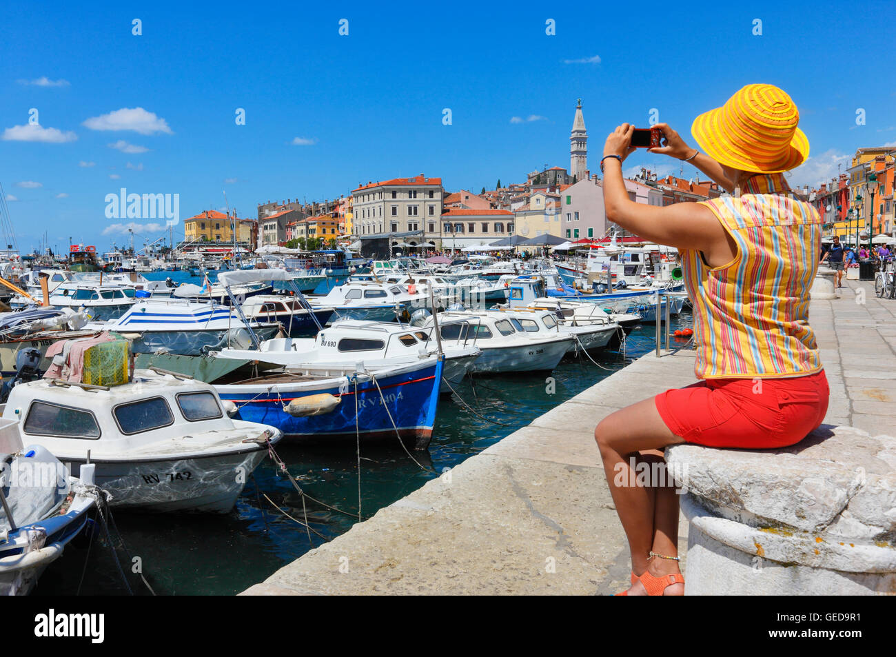 Donna con cappello colorato di scattare le foto della città vecchia di Rovigno Foto Stock