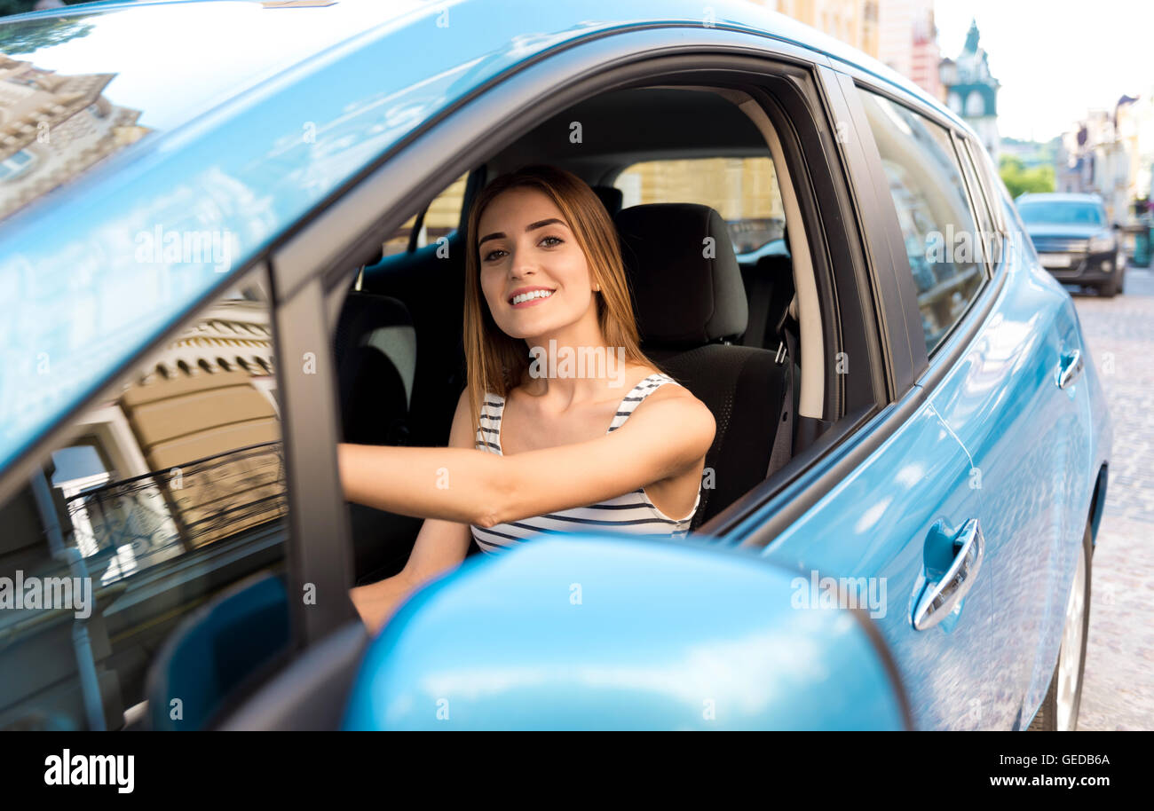 Donna seduta al volante della vettura Foto Stock