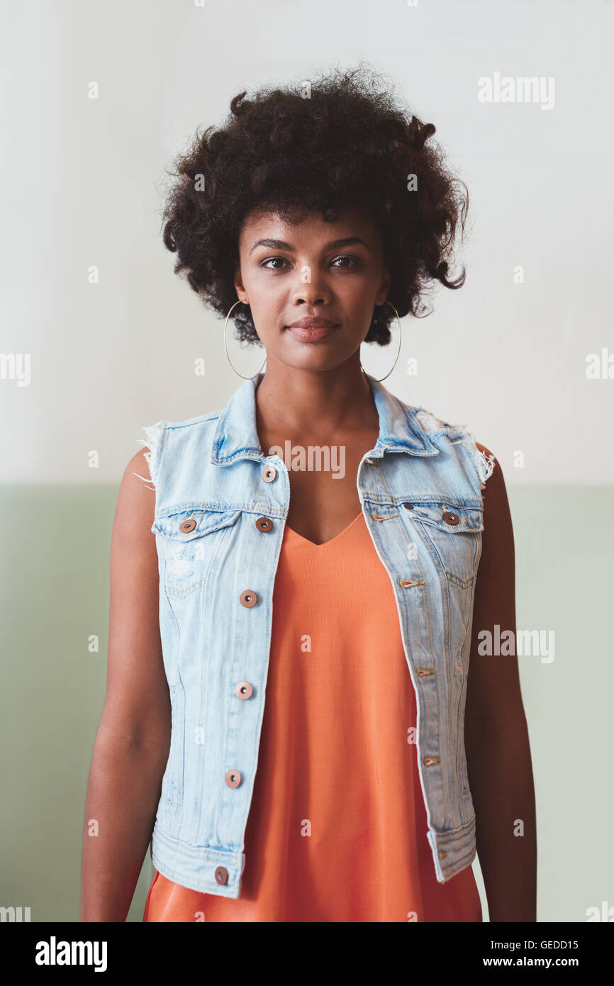 Ritratto di giovane e bella donna che guarda la telecamera con fiducia. African modello femminile guardando fiduciosi in smart casuals. Foto Stock