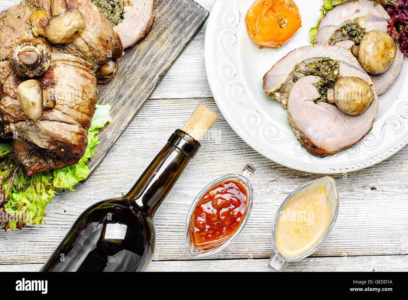 Tavolo da pranzo insieme con vino e piatti di carni cotte al forno focaccia Foto Stock