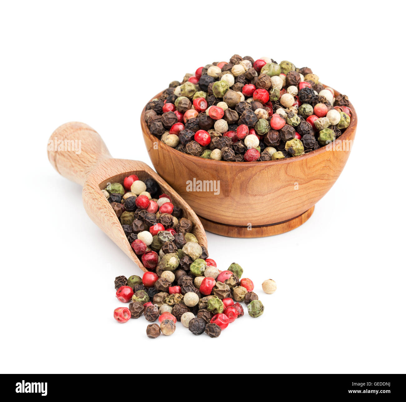Peppe mescolare in una ciotola di legno isolato su bianco Foto Stock