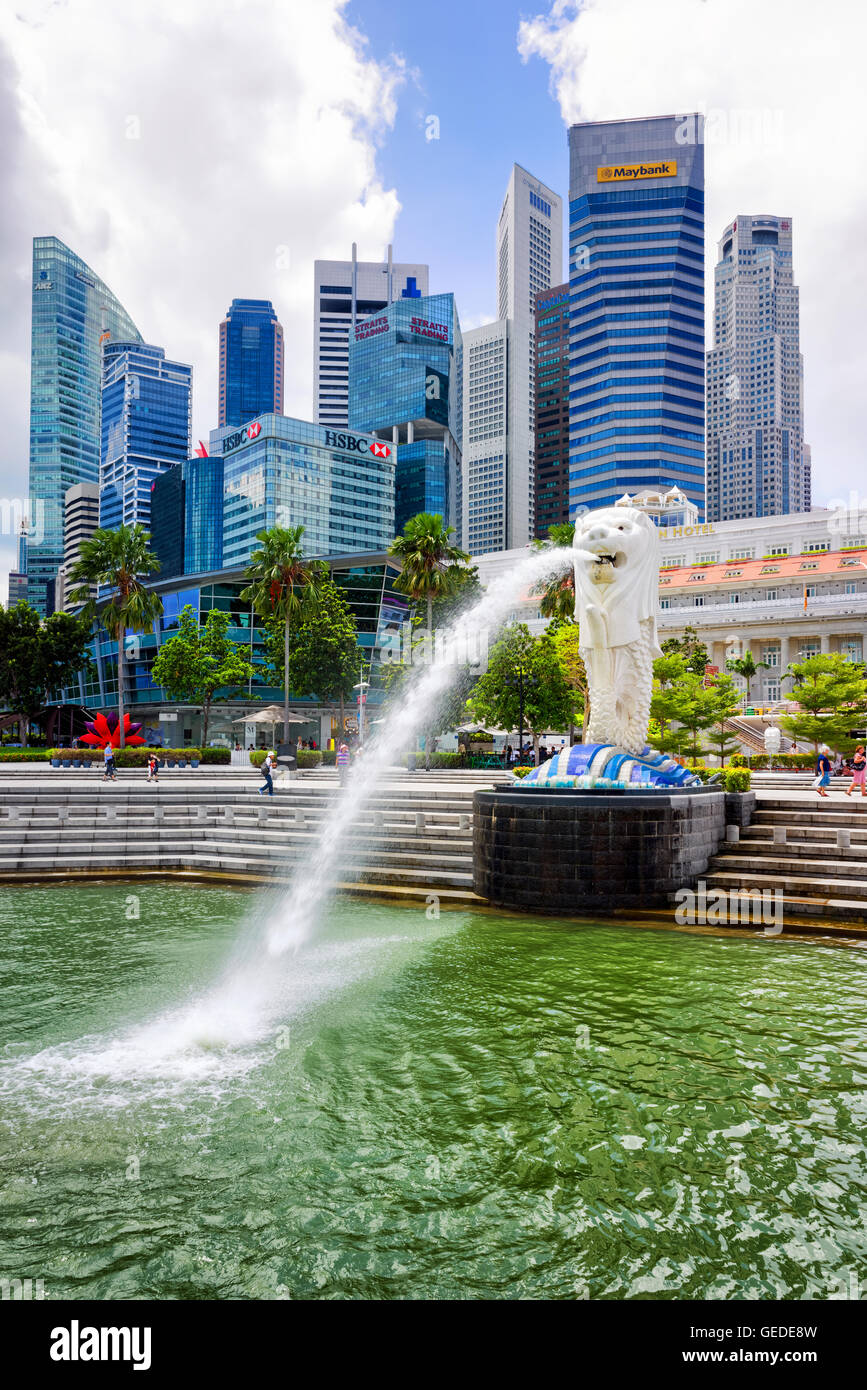 Singapore, Singapore - 1 Marzo 2016: statua Merlion la spruzzatura di acqua dalla sua bocca al Merlion Park nel centro cittadino di nucleo di Singapore presso il Marina Bay. Skyline con grattacieli sullo sfondo. Foto Stock