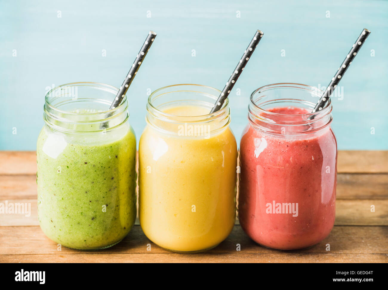 Tre vasi di frullati di frutta fresca con vari colori e sapori. Verde, giallo, rosso. Foto Stock