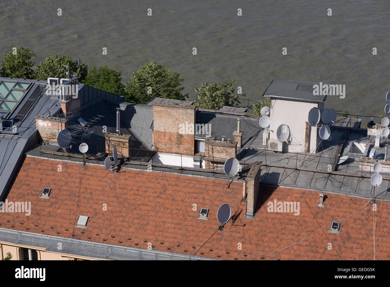 Brown tetto di tegole con più antenne paraboliche accanto al Danubio su Friedrich nato quay Foto Stock