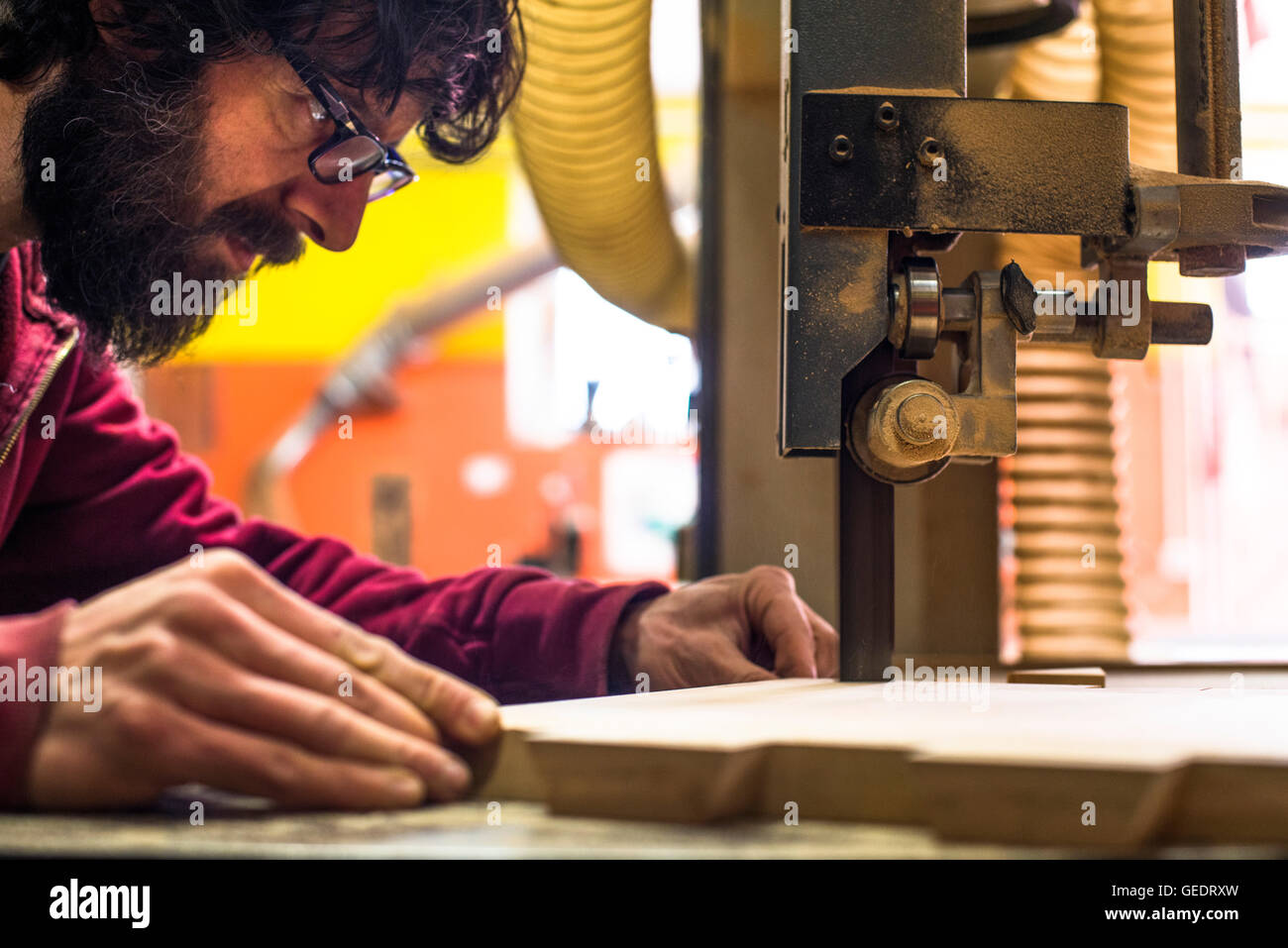 Falegname il taglio di legno con una sega a nastro Foto Stock