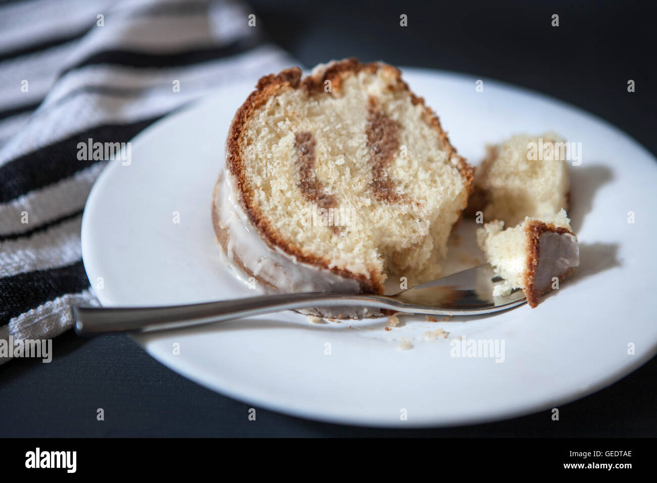 Fetta di panna acida torta di caffè con sciroppo d'acero smalto con la forcella sulla piastra Foto Stock